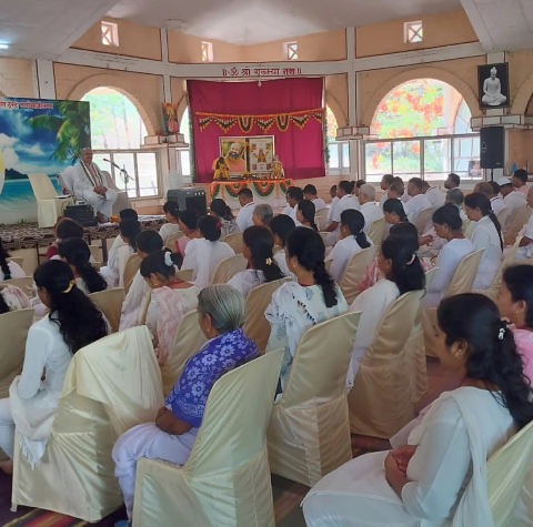 Participants seated for satsang during an SSY camp inside the pyramid hall